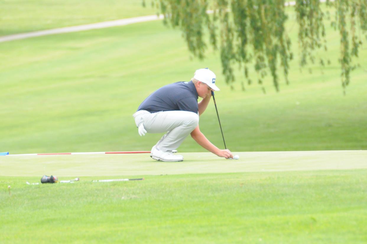 Sacred Heart's Walker Tuttle positions his golf ball on the green during the Class 2A state golf tournament Monday, May 23, 2022, at Emporia Municipal Golf Course.