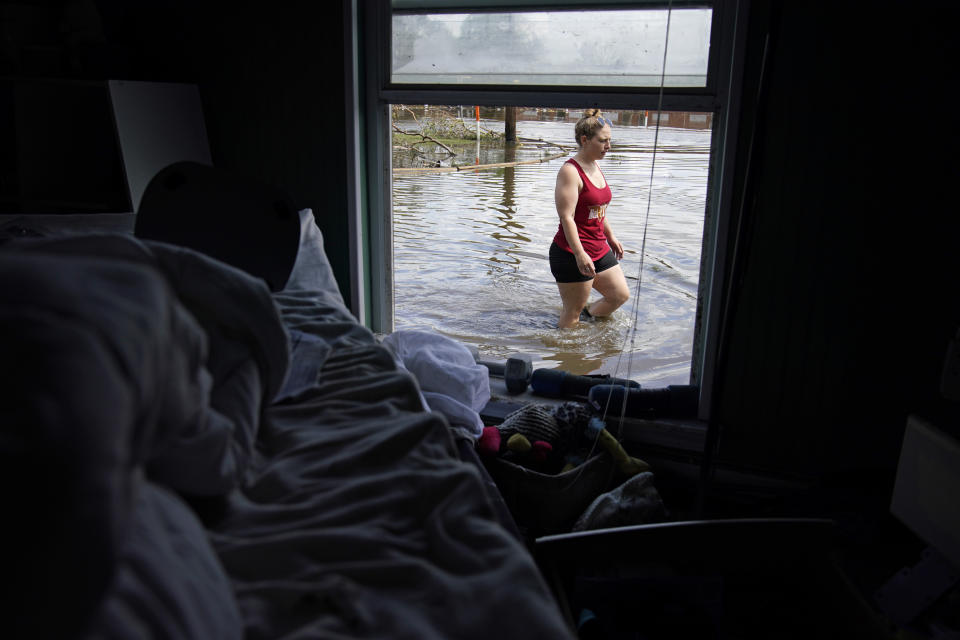 Emily Francois walks through flood waters beside her flood damaged home in the aftermath of Hurricane Ida, Wednesday, Sept. 1, 2021, in Jean Lafitte, La. Louisiana residents still reeling from flooding and damage caused by Hurricane Ida scrambled Wednesday for food, gas, water and relief from the sweltering heat as thousands of line workers toiled to restore electricity and officials vowed to set up more sites where people could get free meals and cool off. (AP Photo/John Locher)