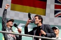 Belgium Formula One - F1 - Belgian Grand Prix 2016 - Francorchamps, Belgium - 28/8/16 - Former Formula One driver Mark Webber of Australia drinks champagne from the shoe of Red Bull's Daniel Ricciardo of Australia (L) while Mercedes' Nico Rosberg of Germany (R) looks on after the Belgian F1 Grand Prix. REUTERS/Yves Herman