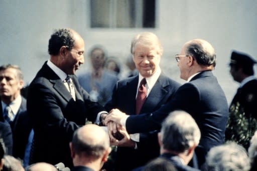 US President Jimmy Carter is between Egypt's President Anwar Sadat (L) and Israeli Prime Minister Menachem Begin (R) at the signature of the Egypt-Israel Peace Treaty on March 26, 1979