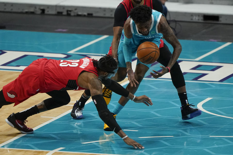 Portland Trail Blazers forward Robert Covington and Charlotte Hornets forward Jalen McDaniels battle for a loose ball during the first half in an NBA basketball game on Sunday, April 18, 2021, in Charlotte, N.C. (AP Photo/Chris Carlson)