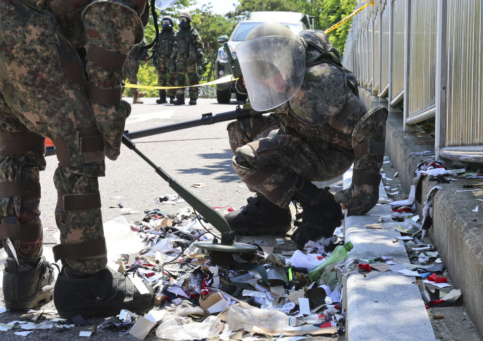 <strong>穿著防護裝備的南韓軍人正在檢查北韓空飄氣球的內容物。（圖／美聯社）</strong>