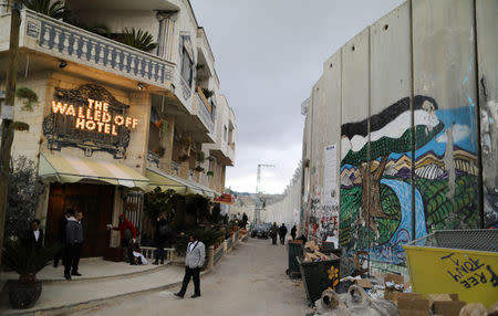 People stand outside the Walled Off hotel, which was opened by street artist Banksy, in the West Bank city of Bethlehem March 3, 2017. REUTERS/ Ammar Awad