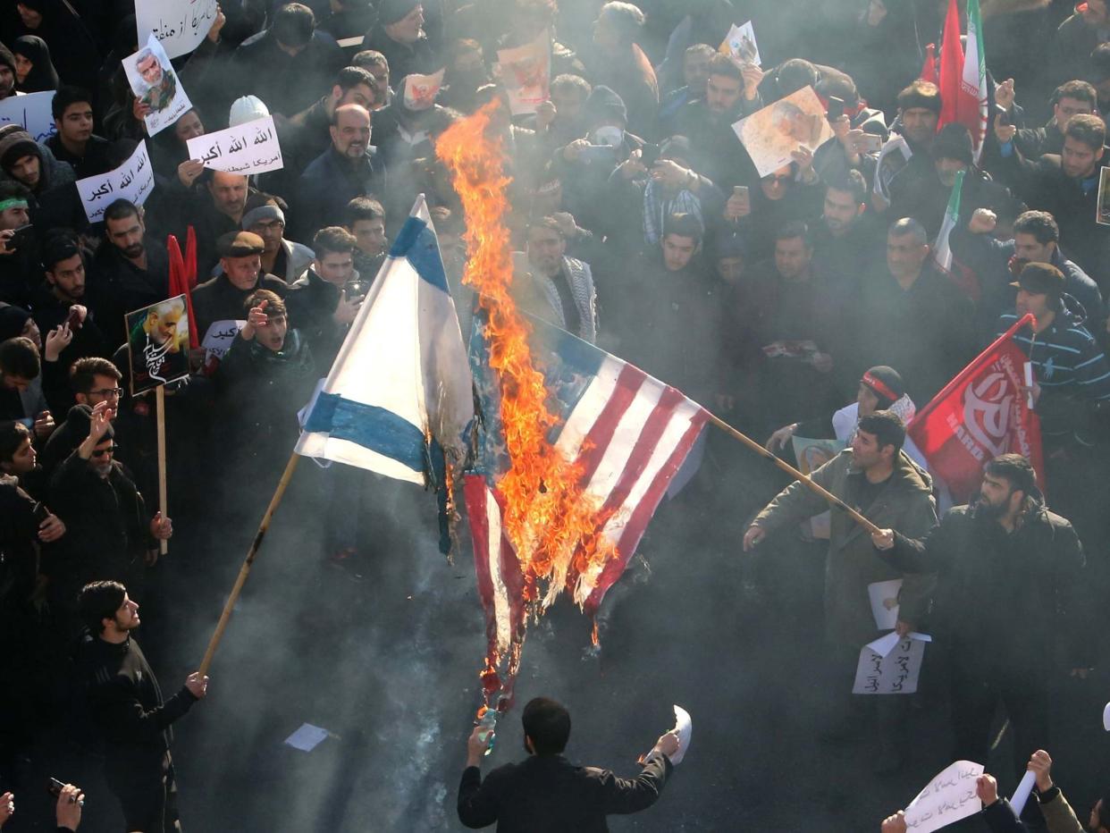 Iranians set a US and an Israeli flag on fire during a funeral procession organised to mourn the slain military commander Qasem Soleimani: AFP/Getty