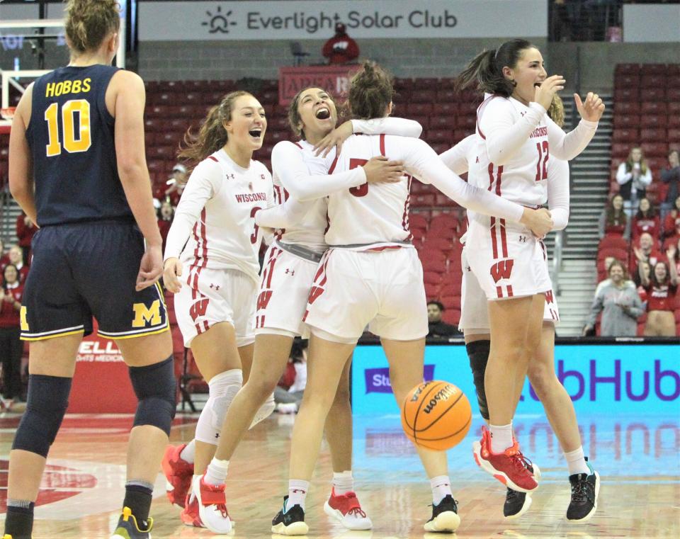 Members of the University of Wisconsin women's basketball team celebrate their 78-70 victory over No. 12 Michigan on Sunday at the Kohl Center in Madison.