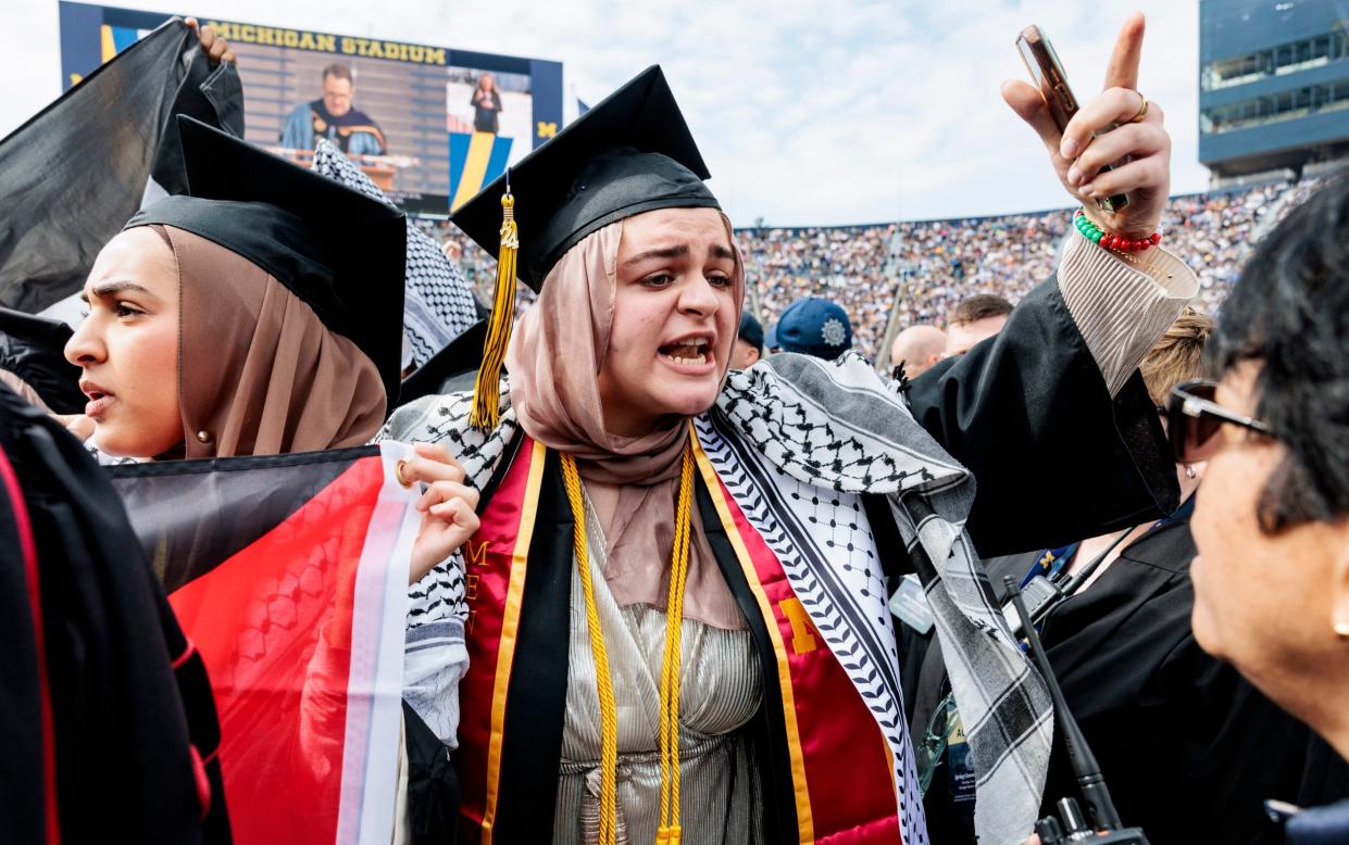 Students wore the traditional keffiyeh headdress and graduation caps as they waved Palestinian flags while walking down the centre aisle of Michigan Stadium