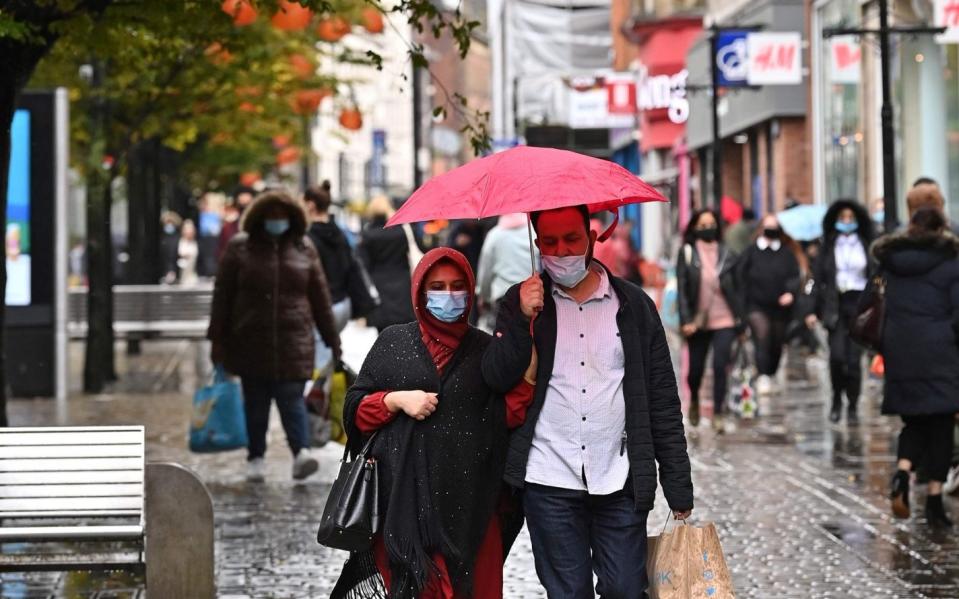 Pedestrians wearing face masks in Manchester after tighter local restrictions were introduced - Paul Ellis/AFP