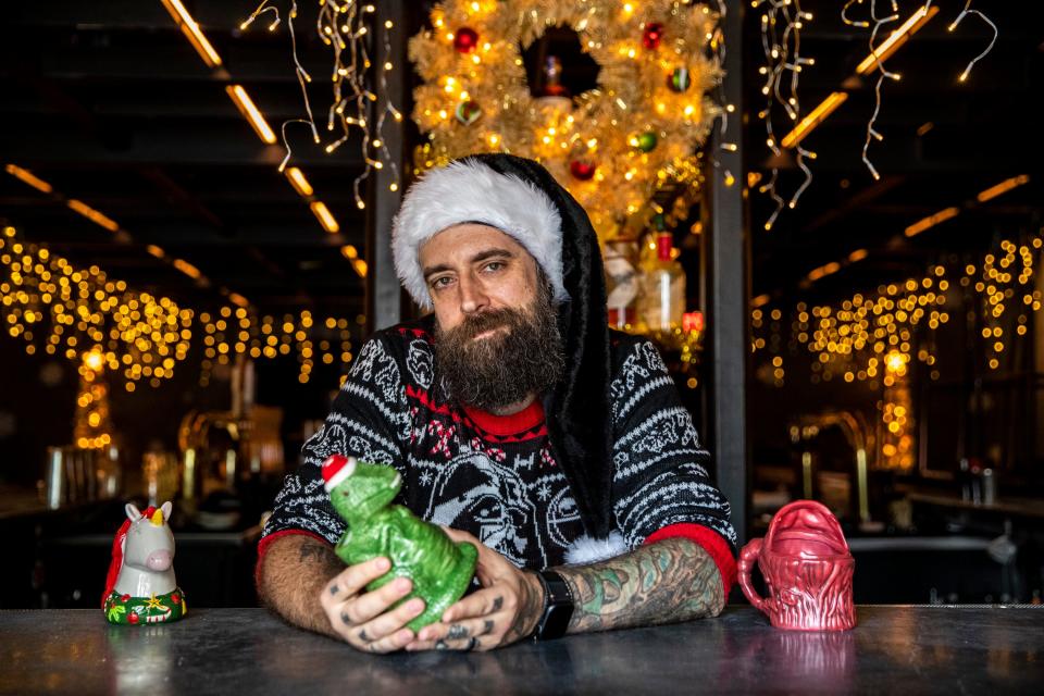 Truss & Twine manager Brandon Glass poses for a photo at the end of the bar as its seen decorated for the Miracle pop-up bar collaboration at Truss & Twine in Palm Springs, Calif., Friday, Nov. 24, 2023.