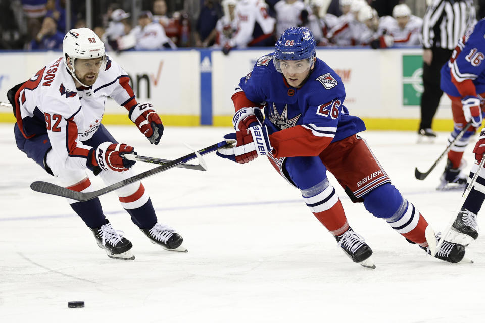 New York Rangers left wing Jimmy Vesey (26) competes for the puck with Washington Capitals center Evgeny Kuznetsov during the second period of an NHL hockey game Tuesday, Dec. 27, 2022, in New York. (AP Photo/Adam Hunger)