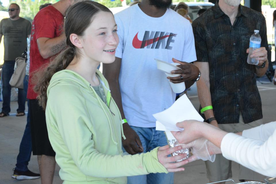 Chloe Kruse receives a chicken shwarma last September from a booth featuring the food from Syrian Kitchen during the Taste of Columbia food festival from the MU Health Care Pavilion at Clary-Shy Park.