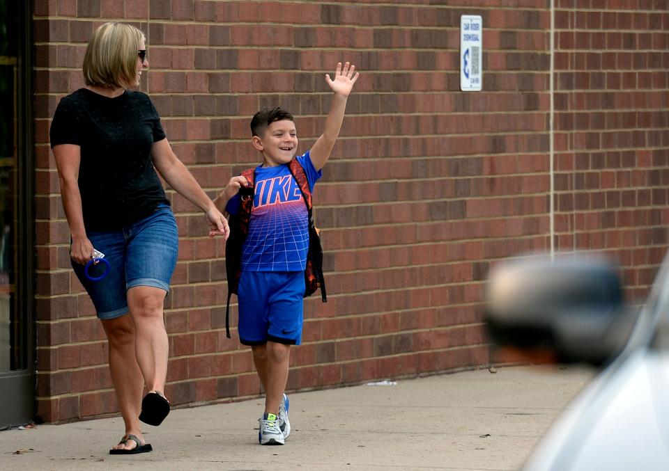 Second grade student, Spencer Vickers, 7, waves to a friend as he arrives with his mother Amanda Vickers for the first day of school at Edmondson Elementary School on Friday, August 6, 2021 in Brentwood, Tenn. 