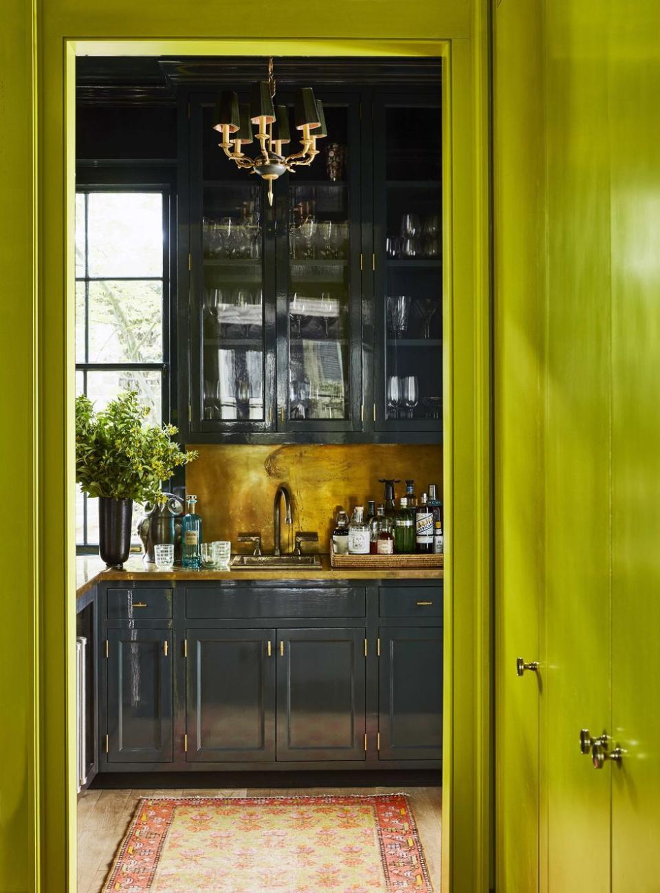 a kitchen with a large glass cabinet and a brass backsplash