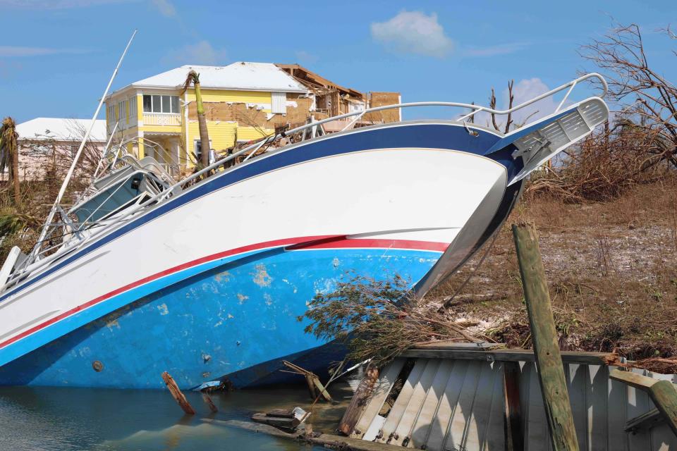 A boat is grounded and a home damaged caused by Hurricane Dorian in Marsh Harbor, Abaco Island, Bahamas, Thursday, Sept. 5, 2019. Dorian has left thousands of desperate hurricane survivors seeking help in the Bahamas. People emerging from shelters and ruined homes have encountered a muddy, ruined landscape. (AP Photo/Gonzalo Gaudenzi)