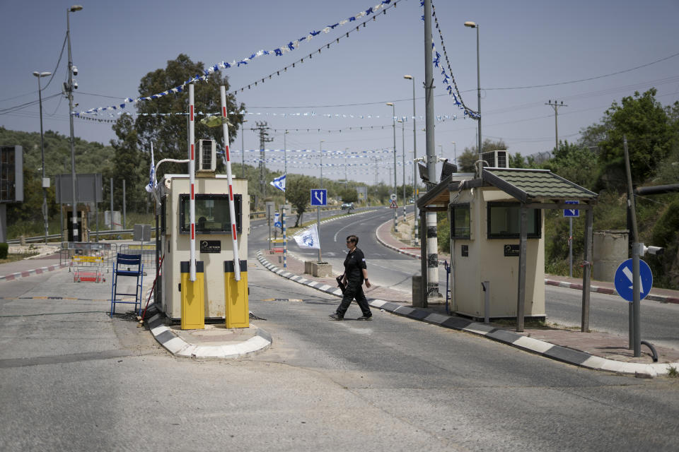 An Israeli security guard secures the entrance to the Jewish settlement of Ariel in the West Bank near the Palestinian city of Nablus, Saturday, April 30, 2022. The Israeli military says it is searching for a pair of Palestinian attackers who shot and killed a security guard at the entrance of a Jewish settlement in the occupied West Bank. The shooting took place late Friday at the entrance to Ariel, a major settlement in the northern West Bank. (AP Photo/Ariel Schalit)