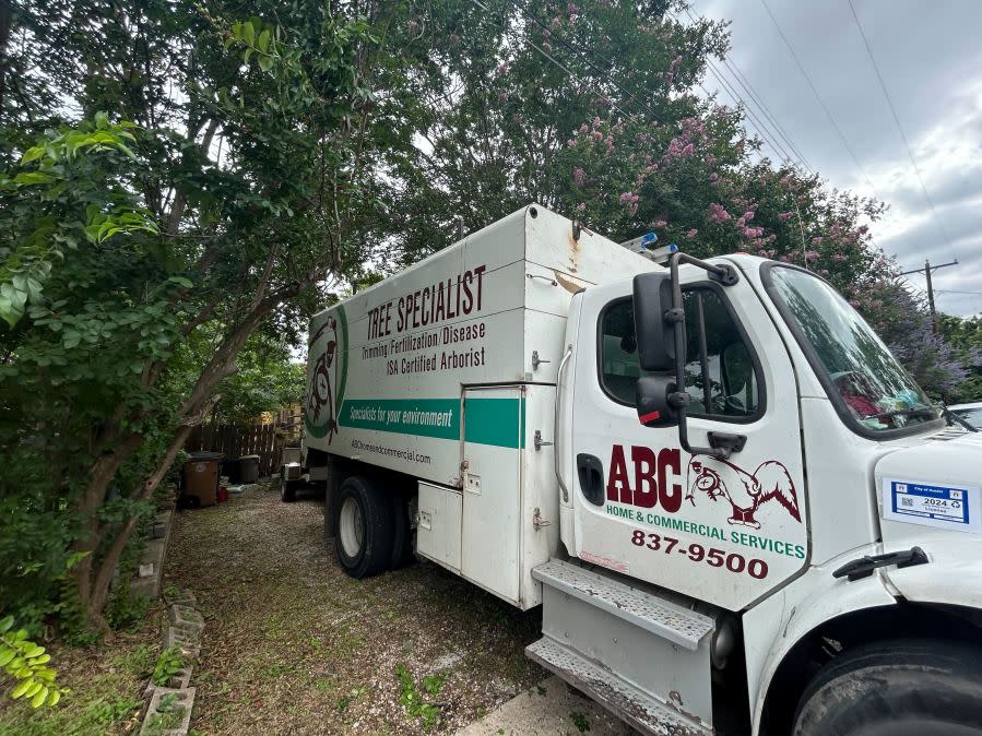 A tree removal crew from ABC Home and Commercial Services helped a family in south Austin remove a tree branch that fell onto their roof. (KXAN photo/Will DuPree)