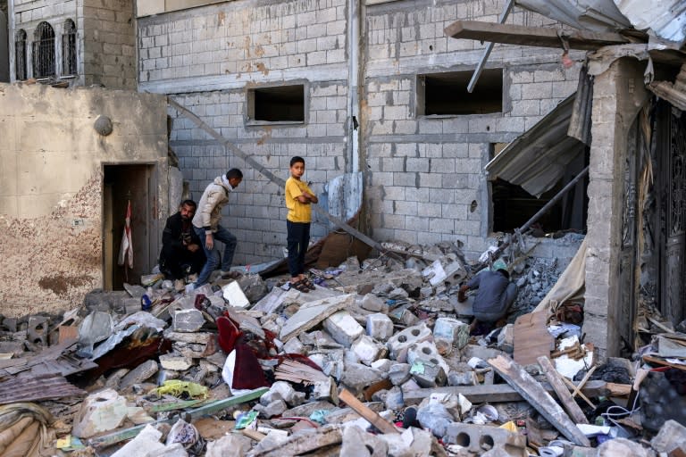 Varias personas inspeccionan los restos de un edificio bombardeado por Israel en Rafah, en el sur de la Franja de Gaza, el 8 de mayo de 2024 (-)