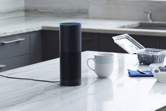 Amazon Echo on a kitchen counter near a coffee cup and blueberries.