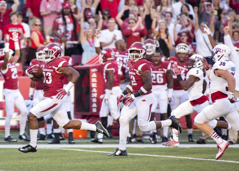 Sep 20, 2014; Fayetteville, AR, USA; Arkansas Razorbacks running back Korliss Marshall (33) returns the opening kick for a touchdown as linebacker Josh Williams (42) looks to block and Northern Illinois Huskies cornerback Mayomi Olootu (5) and wide receiver Skyler Monaghan (38) pursue during the first half of a game at Donald W. Reynolds Razorback Stadium. Mandatory Credit: Beth Hall-USA TODAY Sports