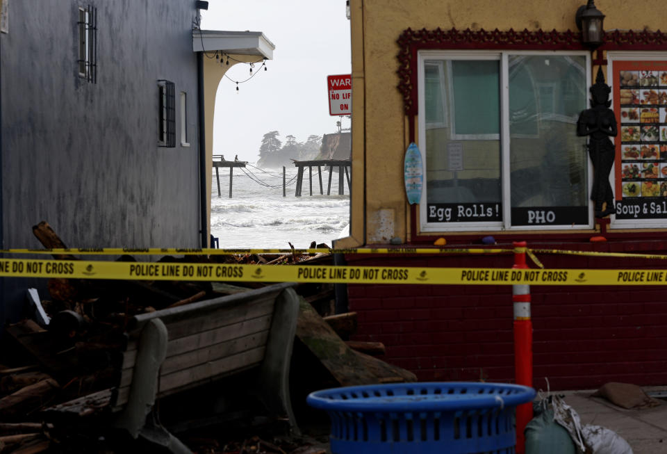 In the distance, a broken bridge, with more damage from the storm surrounding it.