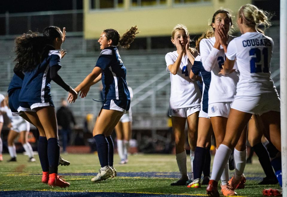 Naples Golden Eagles players celebrate a goal as Barron Collier Cougars players place their hands over their mouths during the final seconds of the second half of the Class 5A regional quarterfinal at Staver Field in Naples on Tuesday, Feb. 13, 2024.