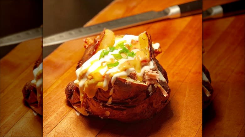 Crispy baked potato with queso, sour cream, and chives