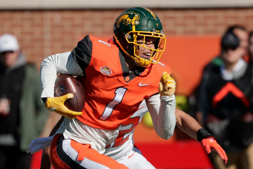 FILE - National Team wide receiver Christian Watson of North Dakota State (1) carries the ball after a reception over American Team cornerback Zyon McCollum of Sam Houston State (32) in the Senior Bowl NCAA college football game, Saturday, Feb. 5, 2022, in Mobile, Ala. Offensive lineman Trevor Penning of Northern Iowa and receiver Christian Watson of North Dakota State, two FCS schools, could be first-rounders in the NFL Draft.  (AP Photo/Butch Dill, File)