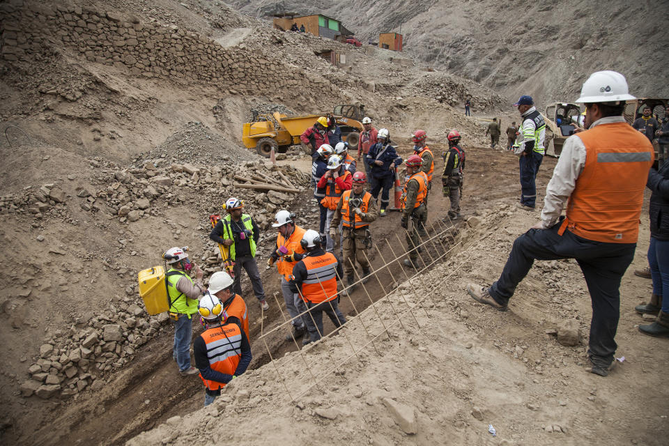 In this photo provided by the regional government of Antofagasta, specialized teams stand outside the San José mine during rescue work for three Bolivian miners trapped deep underground since it collapsed the night before in Tocopilla, Chile, Friday, June 14, 2019. Local authorities confirmed that the men are alive. (Ricardo Rodriguez/Intendencia de Antofagasta via AP)