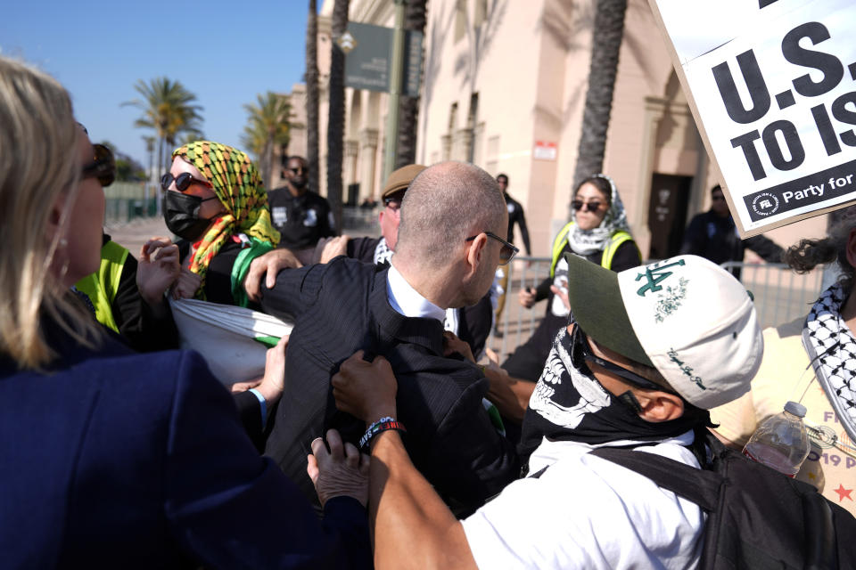 Pro-Palestinian demonstrators attempt to keep attendees from getting through at the Shrine Auditorium where a commencement ceremony for graduates from Pomona College was being held, Sunday, May 12, 2024, in Los Angeles. (AP Photo/Ryan Sun)