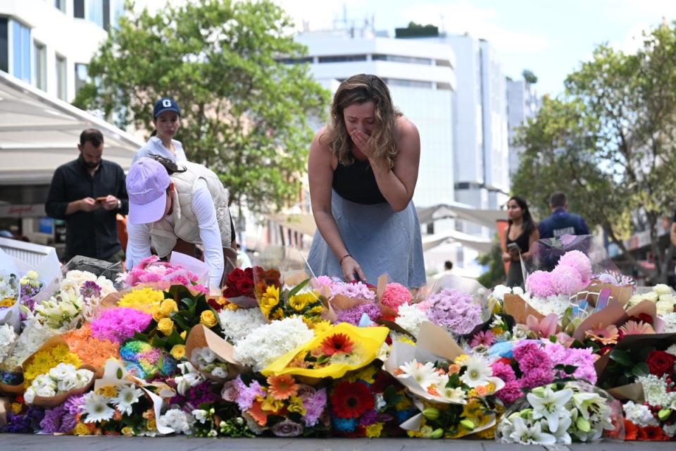 People pay their respects at the scene of the 13 April stabbing rampage at Bondi Junction in Sydney (EPA)