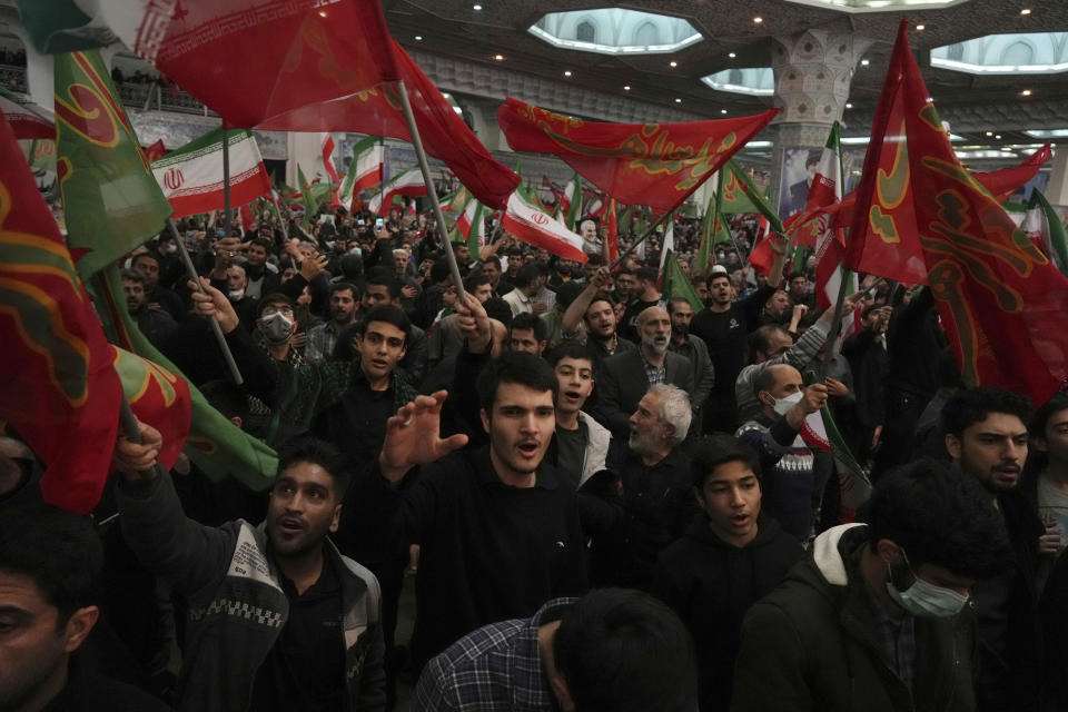 Mourners chant slogans as they wave Iranian and Islamic flags during a ceremony marking anniversary of the death of the late Revolutionary Guard Gen. Qassem Soleimani, who was killed in Iraq in a U.S. drone attack in 2020, at Imam Khomeini Grand Mosque in Tehran, Iran, Tuesday, Jan. 3, 2023. Iran's President Ebrahim Raisi on Tuesday vowed to avenge the killing of the country's top general on the third anniversary of his death, as the government rallied its supporters in mourning amid months of anti-government protests. (AP Photo/Vahid Salemi)