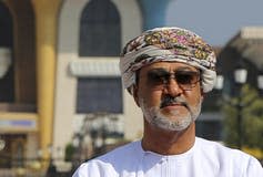 A man wearing a head scarf and sunglasses.