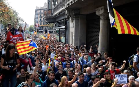 People holding 'Esteladas' (Catalan pro-independence flags) attend a protest in front of the Economy headquarters of Catalonia's regional government - Credit: LLUIS GENE/AFP/Getty Images