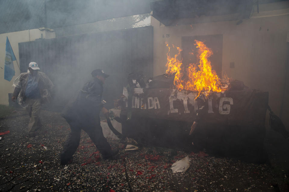 FILE - In this Sept. 3, 2019 file photo, men burn a paper figure of Ivan Velasquez, the commissioner of the United Nations International Commission Against Impunity, CICIG, outside its headquarters which on this day ends its mission, in Guatemala City. After the CCIG’s investigations touched the inner circle of current President Jimmy Morales and the president himself, he shut the commission down and it ceased functioning Sept. 3 when its mandate ran out without being renewed. (AP Photo/Moises Castillo, File)