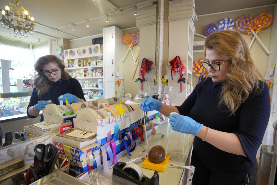 Niaz Mardan wraps a luxury handmade Belgian chocolate Easter egg at Sandrine a chocolate shop in south west London, Thursday, March 21, 2024. Niaz Mardan, is suffering due to high cocoa prices, she's making no profits and fears she will have to close the shop that's been around for 25 years (she's the third owner and took over in 2019). (AP Photo/Kirsty Wigglesworth)