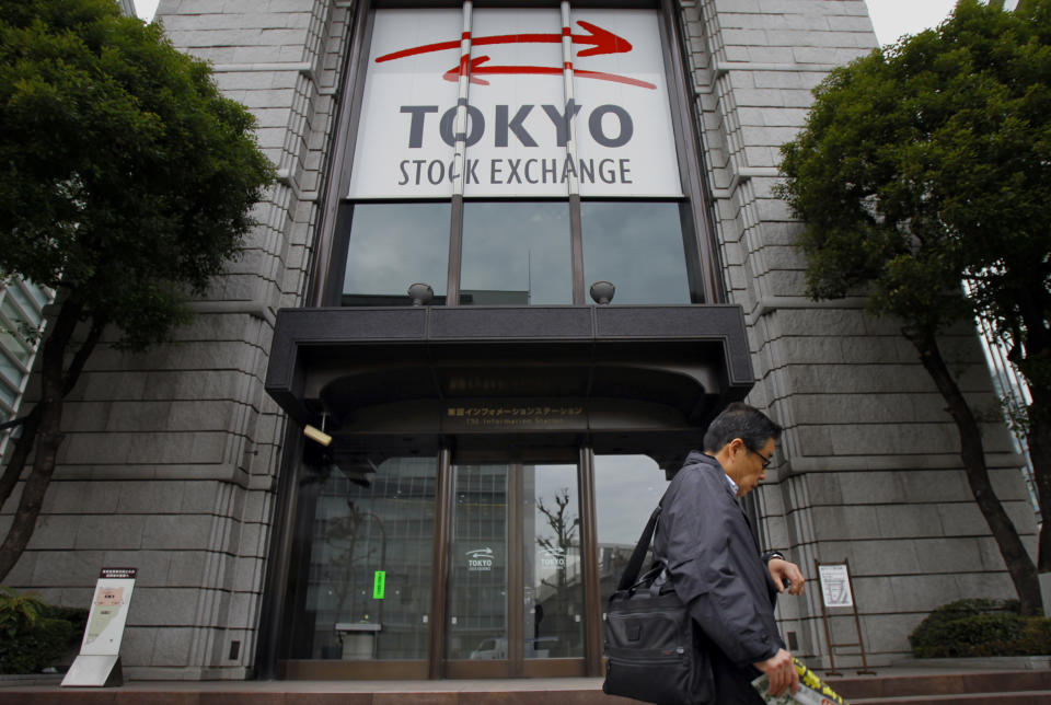 In this Thursday, Feb. 13, 2014 photo, a man walks by Tokyo Stock Exchange in Tokyo. Despite Japan’s prime minister Shinzo Abe's declaration that “Japan is back” in a speech last year to the New York Stock Exchange, he faces a thornier challenge in ensuring that his “Abenomics” recovery from two decades of economic stagnation spreads beyond boardrooms and investment portfolios. (AP Photo/Junji Kurokawa)