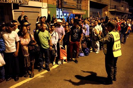 A Venezuelan soldier talks to people waiting to cross the Simon Bolivar international bridge to Colombia in San Antonio del Tachira, Venezuela, August 13, 2016. REUTERS/Carlos Eduardo Ramirez