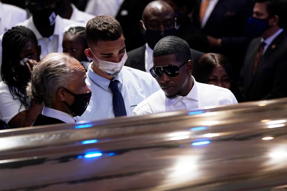 Quincy Mason Floyd, son, of George Floyd pauses at the casket and speake with the Rev. Al Sharpton, left, during a funeral service for Floyd at The Fountain of Praise church, June 9, 2020, in Houston. 