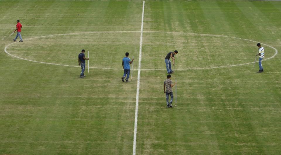 Workers maintain the pitch after a soccer training by Brazil&#39;s national team ahead of their friendly soccer match against Japan in Singapore October 13, 2014. The New Zealand Maori&#39;s non-cap rugby test against the invitational Asia Pacific Dragons in Singapore next month is in doubt as the hosts battle to repair a problematic pitch at their new National Stadium. The surface was laid in May but lacked an appropriate bedding period and has been re-seeded four times, staff said on Monday, as they try to cope with the demands of hosting so many different events in a tropical climate. The sandy pitch, with plenty of bare patches, will host Brazil in a soccer friendly against Asian Cup holders Japan on Tuesday, with organisers of the Southeast Asian soccer championships voicing concerns about Singapore&#39;s ability to part-stage their event in late November-early December. REUTERS/Edgar Su (SINGAPORE - Tags: SPORT SOCCER RUGBY)