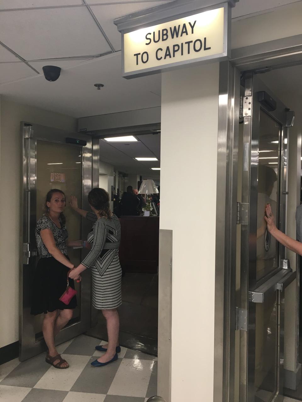 Heather Berube (left) and Natalie Boland (right) glued themselves to underground shuttle entrances in the U.S. Capitol on Tuesday to protest climate change.