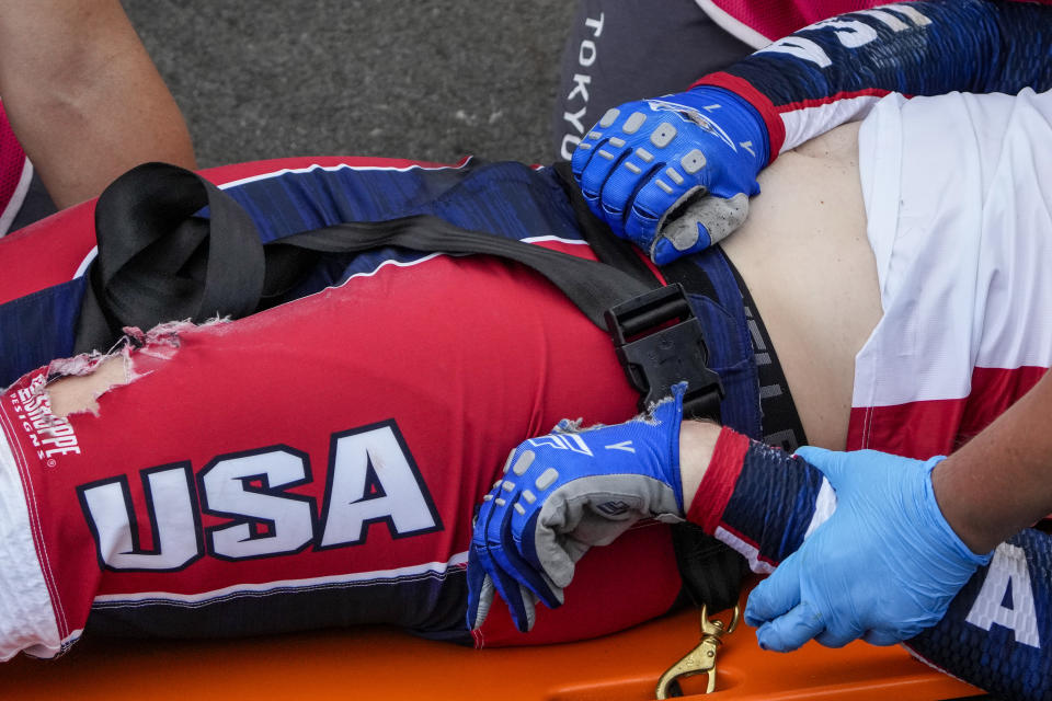 Medics prepare to carry away on a stretcher Connor Fields of the United States after he crashed at the first bend in the men's BMX Racing semifinals at the 2020 Summer Olympics, Friday, July 30, 2021, in Tokyo, Japan. (AP Photo/Ben Curtis)