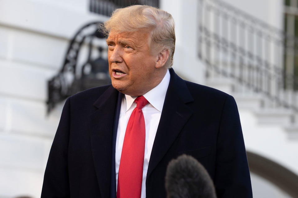 US President Donald Trump talks to the media outside the White House.