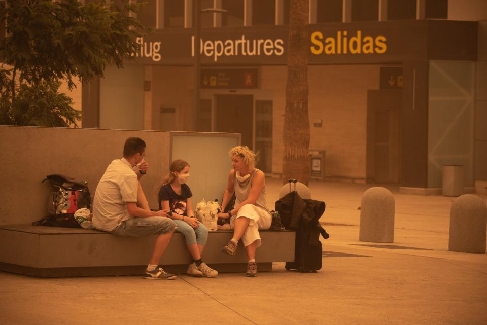 Passengers wait outside Tenerife SouthReina Sofia Airport after flights were cancelled due to a sandstorm on February 23, 2020 on the Canary Island of Tenerife.