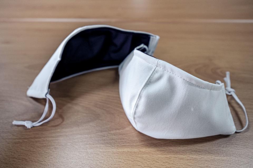 由大愛感恩科技公司提供防水布料，巧藝坊志工精心縫製為藍色內裏、白色外層的布口罩。