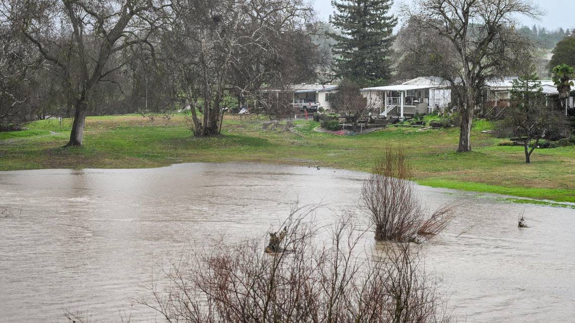 San Joaquin River water creeps toward mobile homes near Highway 41 in north Fresno as rain continues during an atmospheric river event on Saturday, Jan. 14, 2023.