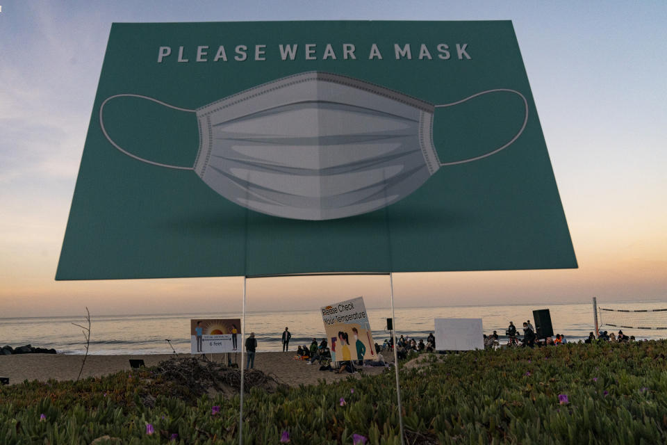 Pastor Will Bredberg, of the First Baptist Church of West Los Angeles, far left, preaches during the Westside Easter Sunrise Service at Will Rogers State Beach park on the Santa Monica Bay on the Pacific Coast in the Pacific Palisades neighborhood of Los Angeles, Sunday, April 4, 2021. (AP Photo/Damian Dovarganes)