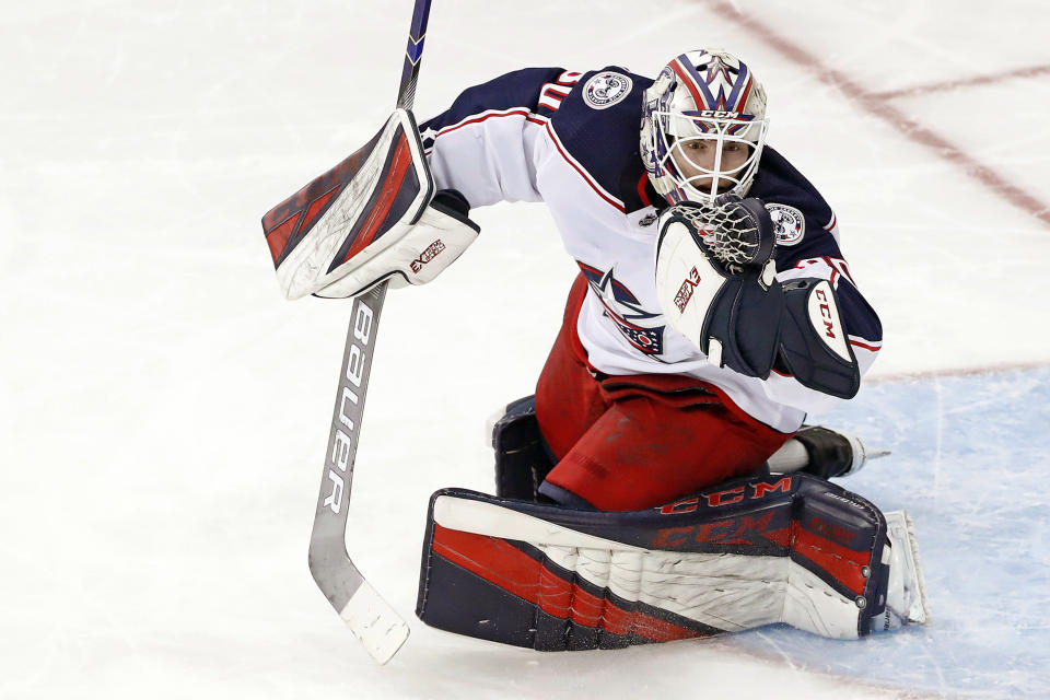 THIS CORRECTS THAT KIVLENIEKS DIED OF CHEST TRAUMA FROM AN ERRANT FIREWORKS MORTAR BLAST AND NOT A SUBSEQUENT FALL AS AUTHORITIES PREVIOUSLY REPORTED - FILE - Columbus Blue Jackets goaltender Matiss Kivlenieks (80) has the puck in his hand as he makes a save during the third period of an NHL hockey game against the New York Rangers in New York, in this Sunday, Jan. 19, 2020, file photo. The Columbus Blue Jackets and Latvian Hockey Federation said Monday, July 5, 2021, that 24-year-old goaltender Matiss Kivlenieks has died. A medical examiner in Michigan says an autopsy has determined that Columbus Blue Jackets goaltender Matiss Kivlenieks died of chest trauma from an errant fireworks mortar blast, and not a fall as authorities previously reported. Police in Novi, Michigan, said the mortar-style firework tilted slightly and started to fire toward people nearby Sunday night, July 4. (AP Photo/Kathy Willens, File)