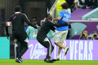 A pitch invader runs is caught while running across the field with a rainbow flag during the World Cup group H soccer match between Portugal and Uruguay, at the Lusail Stadium in Lusail, Qatar, Monday, Nov. 28, 2022. (AP Photo/Petr David Josek)
