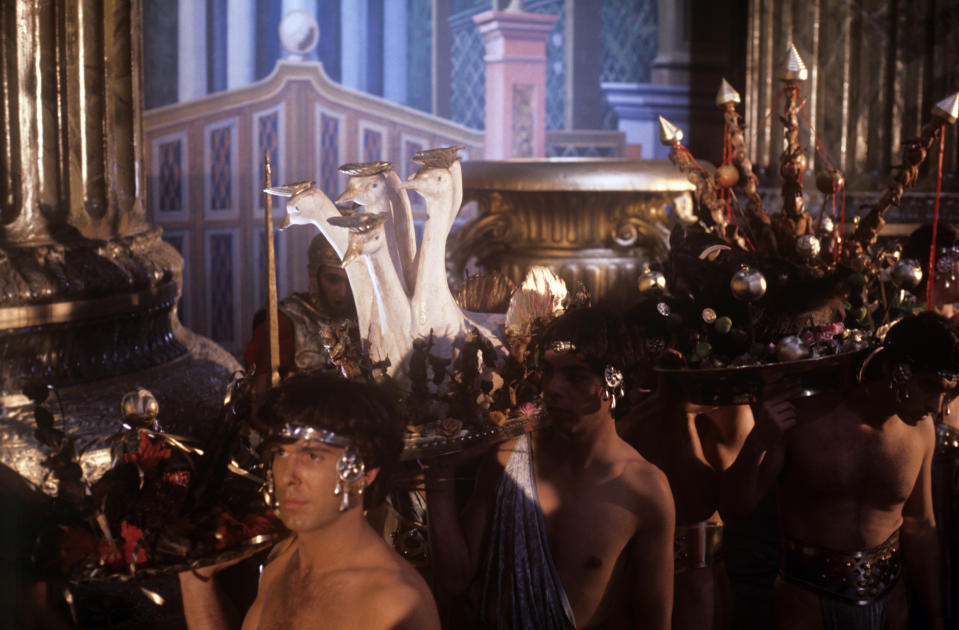 Extras carrying courses on sumptuous trays during a dinner in the film Caligula, My Son. 1979. (Photo by Mondadori via Getty Images)