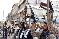 Tribal gunmen loyal to the Huthi movement brandish their weapons in the capital Sanaa on April 1, 2015, during a demonstration against the Saudi-led coalition operation