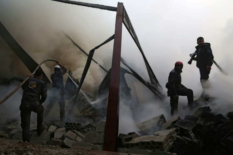 Syrian civil defence volunteers, known as the White Helmets, extinguish fire reportedly caused by air strikes in the rebel-controlled town of Hamouria, in the eastern Ghouta region on the outskirts of the capital Damascus, on March 21, 2017